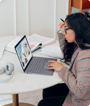 A professional at work beside an open notebook and laptop
