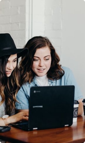 Two colleagues working through a plan at a shared laptop